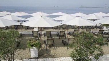 Hafta sonu kumsalda güneşli turistler. Sahilde güneşin ve denizin tadını çıkaran insanlarla dolu bir gün. Soçi, Rusya