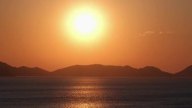 Güzel gün doğumu. Turuncu ve altın rengi mavi gökyüzü. Altın deniz. Gün doğumunda sahilde dalgaların sesi. Gün batımı. Deniz manzaralı gün batımı. Denizden çıkan sarı güneş. Turuncu gün batımı