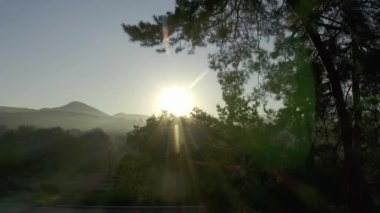 Kırsal kesimde sabahın erken saatlerinde aydınlık bir şafak. Sıcak sabah güneşi altında doğal vahşi doğanın manzarası. Sis içinde gün doğumu şafağın altın ışığı. Doğa. Hava görünümü. 
