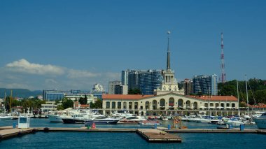 Sochi, Rusya - 20 AUG 2020: Sochi, Rusya limanında yatlar ve tekneler. Limandaki deniz manzarası güneşli ve yumuşak. Güneşli bir günde deniz istasyonu inşaatı. 