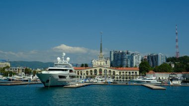 Sochi, Rusya - 20 AUG 2020: Sochi, Rusya limanında yatlar ve tekneler. Limandaki deniz manzarası güneşli ve yumuşak. Güneşli bir günde deniz istasyonu inşaatı. 