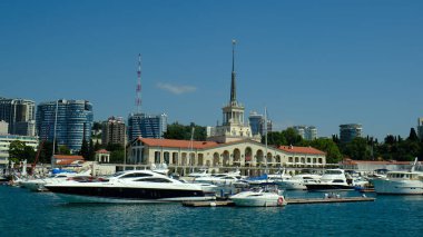Sochi, Rusya - 20 AUG 2020: Sochi, Rusya limanında yatlar ve tekneler. Limandaki deniz manzarası güneşli ve yumuşak. Güneşli bir günde deniz istasyonu inşaatı. 