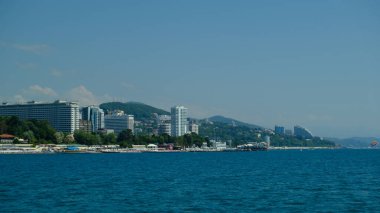 Yazın Soçi sahilinin panoraması. Geniş format. Karadeniz, Rusya. Deniz manzarası. İnsan yok. Güneşli bir gün. Sahildeki modern şehir..