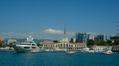 Sochi, Rusya - 20 AUG 2020: Sochi, Rusya limanında yatlar ve tekneler. Limandaki deniz manzarası güneşli ve yumuşak. Güneşli bir günde deniz istasyonu inşaatı. 