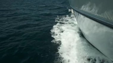 Pruvadaki yatın güvertesinden bak, yaklaş. Yeşil deniz ve dalgalarla yan manzara. Kavram, yaşam tarzı ve özgürlük. Yavaş çekim.