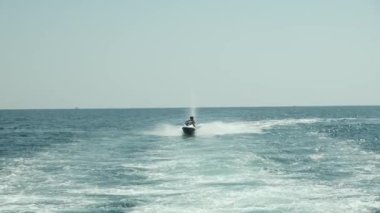 Su motosikletine binen iki adam. Kumsal tatilinde spor ve okyanus aktiviteleri. jet ski