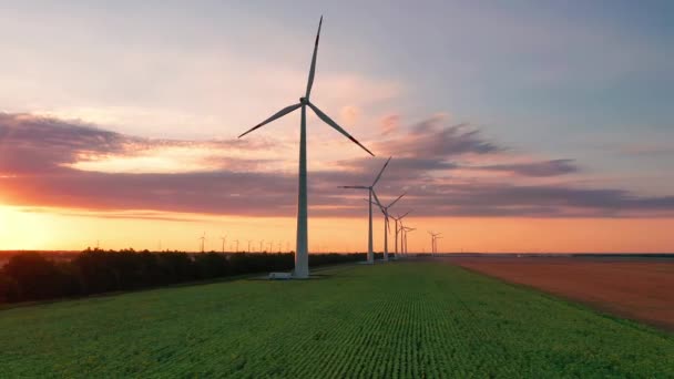 Letecký pohled na stojící větrné turbíny. Letecký pohled na farmu s větrnými turbínami. Vytváření čisté obnovitelné energie. jasně oranžový větrný park západu slunce zpomaluje. Alternativní energie — Stock video