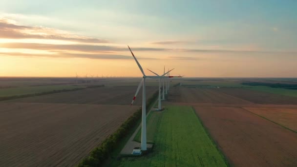 Grandes éoliennes avec pales sur le terrain vue aérienne coucher de soleil orange vif. wind park slow motion drone turn. éoliennes. Énergie alternative. Vue aérienne des éoliennes Production d'énergie. — Video