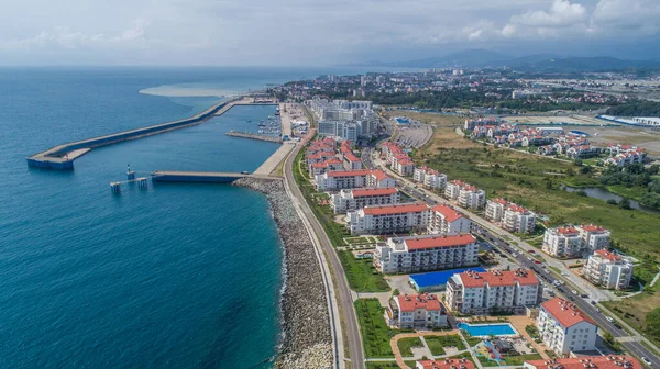 Soçi 'deki Yaz Olimpiyat Parkı' nda Karadeniz 'in mavi sahil manzarası. Modern ev. Deniz limanı. Imeretinsky tatil köyü. İHA atışı. Yukarıdan. Tekne. Yahts. Malikane. Geliştirme. 