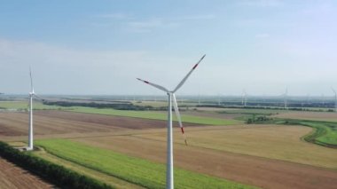 Rüzgar türbinleri elektrik üretir. Rüzgâr değirmeni güç teknolojisi. Hava aracı görüntüsü Enerji Üretimi. Yeşil alan. Üst hava manzarası, yukarı doğru hareket ediyor. Rüzgarları kinetik enerjiye dönüştürür.. 