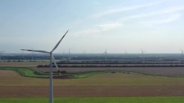 Elektrik üreten rüzgar türbinleri. Rüzgâr değirmeni güç teknolojisi. Enerji Üretiminde hava aracı görüntüsü. Rüzgâr türbinleri yeşil bir alanda duruyor. Kapat.. 