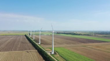 Rüzgar türbinleri elektrik üretir. Rüzgâr değirmeni güç teknolojisi. Hava aracı görüntüsü Enerji Üretimi. Yeşil alan. Üst hava manzarası, yukarı doğru hareket ediyor. Rüzgarları kinetik enerjiye dönüştürür.. 