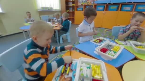 Bambini che giocano con mattoni di plastica all'asilo — Video Stock