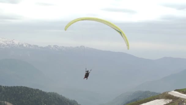 Parapente con dos personas. Volando sobre montañas — Vídeos de Stock