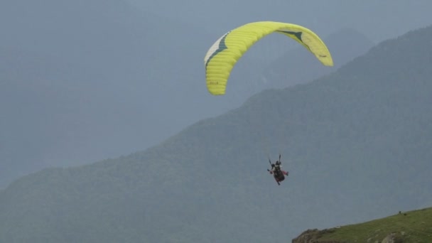 Parapente com duas pessoas sobre montanhas em câmera lenta — Vídeo de Stock