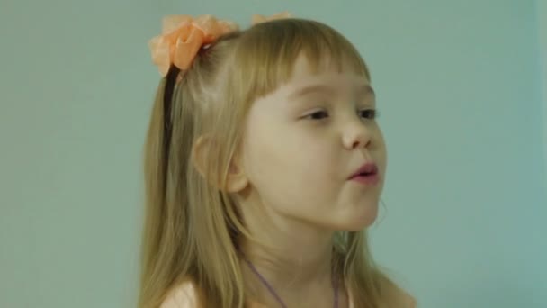 Little girl blowing on a paper snowflake — Stock Video