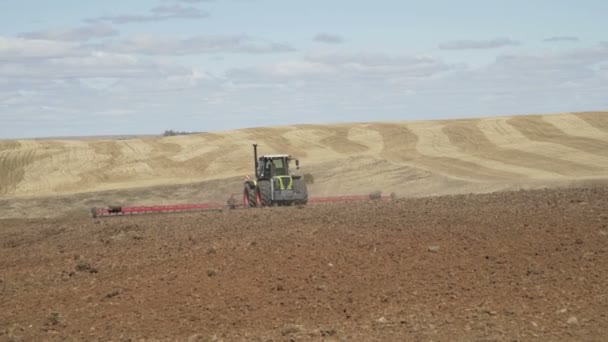 Lantbruks traktor som rör sig på jordbruks området för plöjning mark. Jordbruks traktor plöjning odlings fält — Stockvideo