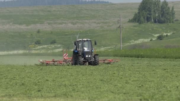 Trator agrícola movendo-se no campo agrícola para a colheita de terras. Máquinas agrícolas no campo de colheita — Vídeo de Stock