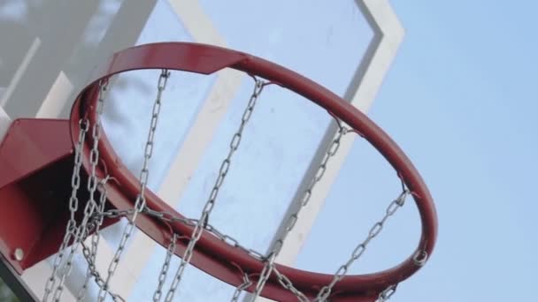 Pallacanestro passando attraverso il canestro da basket nel campo da basket — Video Stock