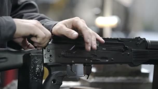 Fabrieksassemblage van een Kalashnikov aanvalsgeweer. Sluit het laadgeweer. Ak47 wordt geladen. Fabrieksarbeider die machinegeweer laadt. Fabrieksarbeider verzamelt de Ak-47. — Stockvideo