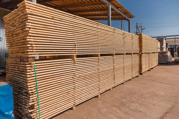 Wood factory stock and lumber board with nature business export. Stack of lumber wood in timber log storage. Wood processing joinery work wooden furniture. Wood timber construction material.