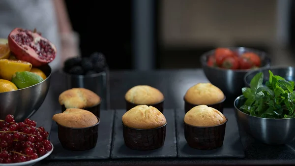 Confectioner making muffins. Modern desserts and cakes. Cupcakes with cream filling. Professional pastry. Stock Picture