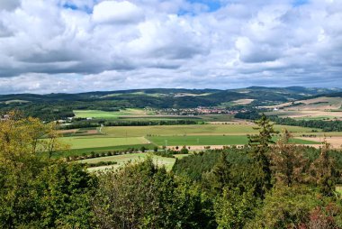 Köy, alanlar, çayır ve orman bulutlu gökyüzü altında ile kırsal bir görünümünü