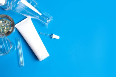 Üstten Görünüm bilim ve tedavi krem losyon aromatik güzellik kozmetik cilt bakım tüp ve mockup ürün üzerinde mavi arka plan ile yakından