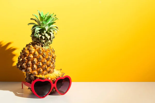 colorful pineapple tropical fruit nature with fashion red heart love sunglasses, hot summer season vacation holiday, yellow background wallpaper