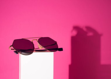pembe renk arka plan ile beyaz kutup üzerinde moda güneş gözlüğü Gadget nesnesi