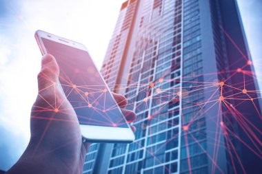 iş kavramı ile ağ arka planda telefon mobil ve bina ile el