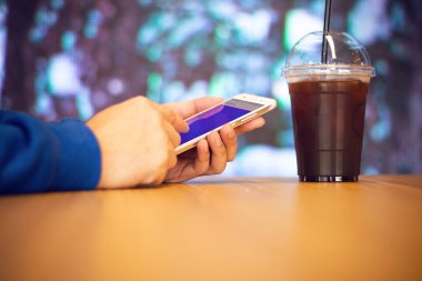 adam iş ağı kavramı dükkanda masada kahve ile akıllı telefon oynamak