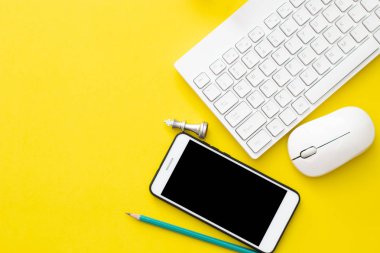 ofis iş nesne kalem, cep telefonu, satranç, klavye ve fare sarı arka plan üzerinde