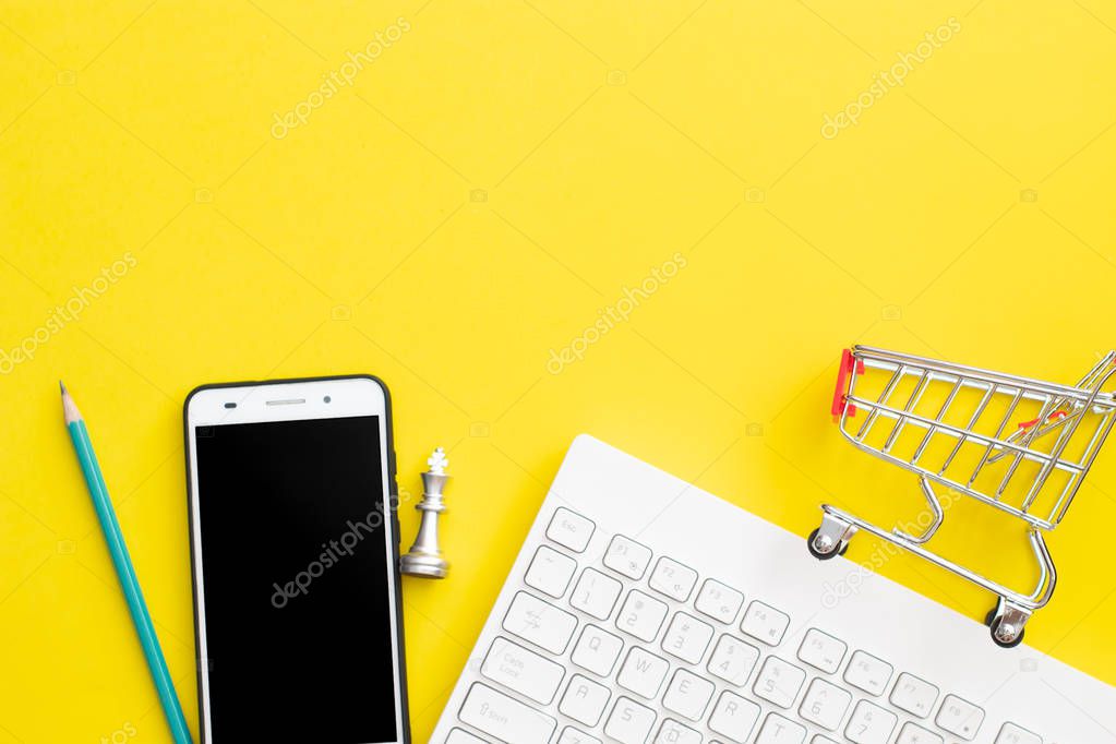office business object calculator, pencil, mobile phone,chess, keyboard and shopping cart on yellow background