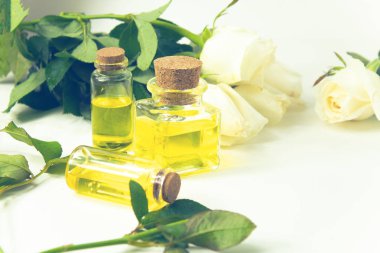 arka planda gül beyaz çiçek ve yeşil yaprak ile kozmetik için parfüm yağı özü