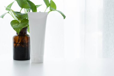 Ürün mockup konteyner kozmetik güzellik losyonu spf güneş kremi yüz köpük ile krem vazo ve yeşil bitki doğa yaprak banyo parlak iç beyaz arka plan ile tüp
