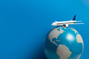seyahat turu uluslararası konsepti için havayolu iş mavi arka plan üzerinde küresel dünya ile beyaz uçak oyuncak modeli