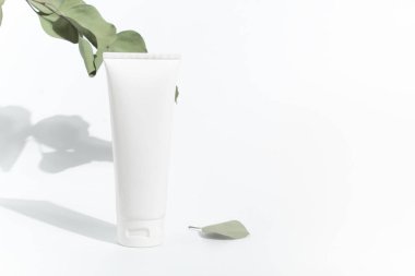 yaprak ağacı bitki dalı ile beyaz arka plan üzerinde güzellik spa tedavi konsepti ile güneş kremi koruma kozmetik mockup krem losyon şişe pakage