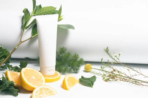 beyaz güzellik tıbbi cilt bakımı şişe tüp ambalaj sağlıklı gıda beslenme limon meyve ve yeşil yaprak bitkisel ağaç dalı arka planda su damlası tazelik ile, yakın