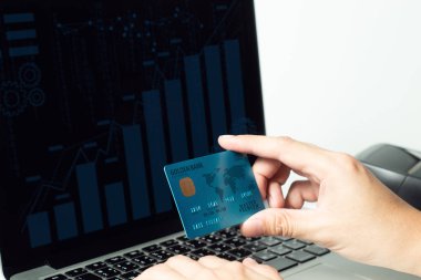 dizüstü bilgisayar cihazı ile online yatırım finansal dijital bankacılık alışveriş için ödeme para prim kredi kartı tutan işadamı