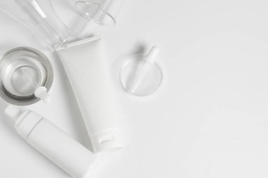 güzellik spa tıbbi cilt bakımı konsepti, bilim doktoru laboratuvar test cam üst görünümü ile beyaz dekor arka plan üzerinde kozmetik losyon şişe ambalaj