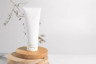 kurutulmuş çiçek bitkisel ağaç dalı ile beyaz dekor arka plan üzerinde kozmetik losyon krem şişe ambalaj tüp ile sağlıklı güzellik spa tıbbi cilt bakımı kavramı