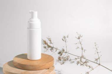 kurutulmuş çiçek bitkisel ağaç dalı ile beyaz dekor arka plan üzerinde kozmetik losyon krem şişe ambalaj tüp ile sağlıklı güzellik spa tıbbi cilt bakımı kavramı
