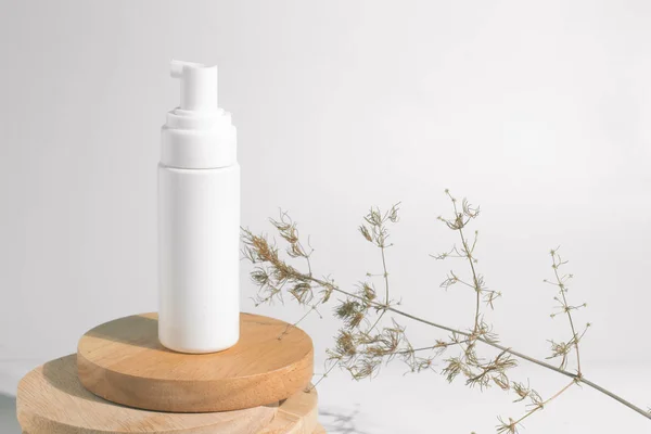 kurutulmuş çiçek bitkisel ağaç dalı ile beyaz dekor arka plan üzerinde kozmetik losyon krem şişe ambalaj tüp ile sağlıklı güzellik spa tıbbi cilt bakımı kavramı