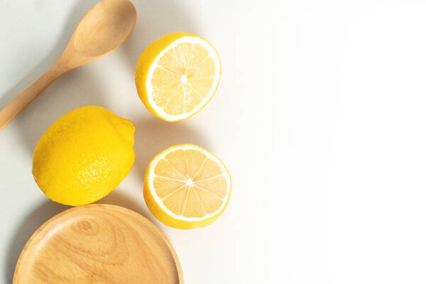 tropical fruit fresh natural lemon with wood cup dish and spoon fork, kitchen table isolated background, organic food and nutrition vitamin citrus, diet and healthy