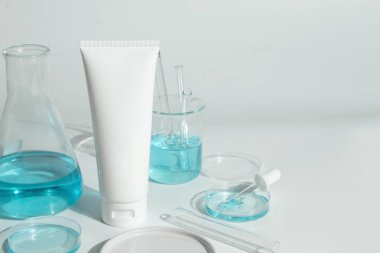 Güzellik kaplıcası tıbbi cilt bakımı ve kozmetik losyon şişesi krem ambalaj ürünü beyaz dekor arka planında laboratuvar bilimi cam tıbbı ile birlikte.