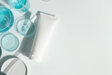 Güzellik kaplıcası tıbbi cilt bakımı ve kozmetik losyon şişesi krem ambalaj ürünü beyaz dekor arka planında laboratuvar bilimi cam tıbbı ile birlikte.