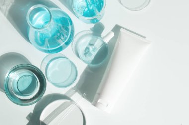 Güzellik kaplıcası tıbbi cilt bakımı ve kozmetik losyon şişesi krem ambalaj ürünü beyaz dekor arka planında laboratuvar bilimi cam tıbbı ile birlikte.