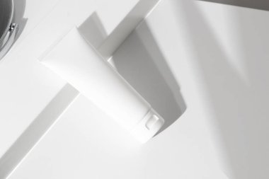 Taze güzellik kaplıcası tıbbi cilt bakımı ve kozmetik krem yüz tüpü beyaz dekor arka planında ambalaj ürünü yaz mevsimi güneşi ışığı