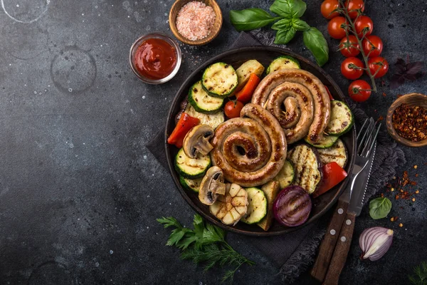黑盘子上的烤螺旋香肠和蔬菜 顶部视图 — 图库照片